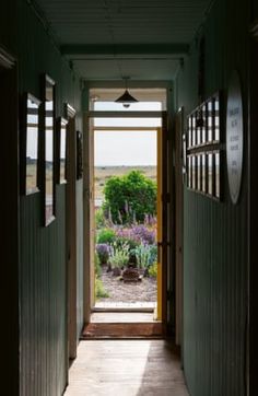 an open door leading into a garden with lavenders in the background and sunlight coming through