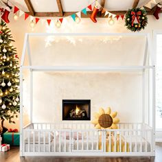 a white crib in front of a christmas tree