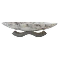 a white marble bowl sitting on top of a metal stand with a black base and grey accents