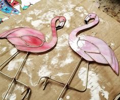 two pink flamingos sitting on top of a table