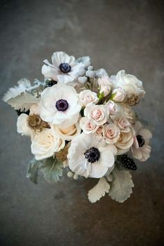 a bouquet of white and pink flowers sitting on top of a table