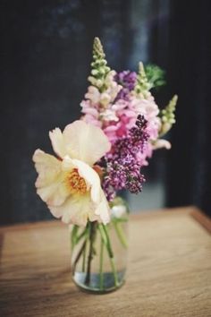 a vase filled with flowers on top of a wooden table