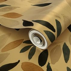 a close up view of a wallpaper with leaves in gold and green colors on it