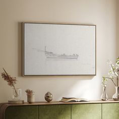 a painting hangs above a green cabinet with vases and flowers on the sideboard