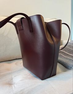 Bordeaux colored leather tote bag sitting on a beige velvet couch Wine Tote, Bag Luxury, Shopper Tote, Gorgeous Bags, Zip Pouch, Leather Craft, Bag Making, Red Wine, Calf Leather