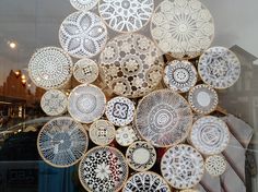 there are many plates on display in the store window and it looks like they have been made out of paper