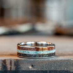 two wedding bands are sitting on top of a wooden table and one has a ring in the middle