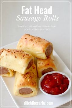 sausage rolls on a plate with ketchup and sauce for dipping in the bowl