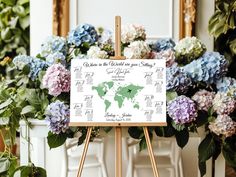 an easel with a map of the world on it in front of some flowers