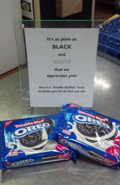 two bags of oreo cookies sitting on top of a counter next to a sign