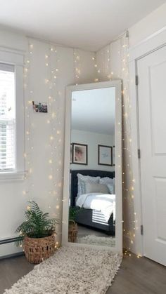 a bedroom with lights on the wall and a mirror in the corner next to it