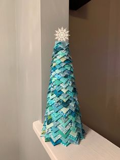 a small christmas tree made out of magazines on top of a shelf in a room