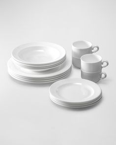 white dishes and cups are stacked on top of each other