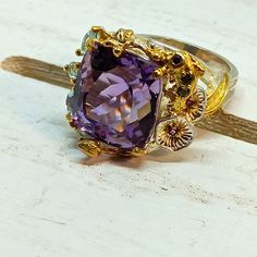 Cushion Cut Amethyst With Gemstone Accents, Limited Editiom. Artist Designed Amethyst Ring Crafted Out Of Solid Sterling Silver With Artist's Signature Use Of 14 Kt Gold Finishes, Topaz, Lily Pads, Coral Creations! This Ring Is Gorgeous! Nwots. New. 3/4 Inch Height X 1 1/4 Inch Wide. Size 8. Exquisite Amethyst Wedding Ring With Gemstone Accents, Luxury Amethyst Rings With Gemstone Accents, Luxury Amethyst Ring With Gemstone Accents As Gift, Exquisite Amethyst Rings With Gemstone Accents, Elegant Amethyst Gemstones With Accent Stones, Formal Fine Jewelry Amethyst Ring, Purple Multi-stone Amethyst Ring In Fine Jewelry Style, Fine Jewelry Purple Amethyst Multi-stone Ring, Purple Multi-stone Amethyst Ring Fine Jewelry