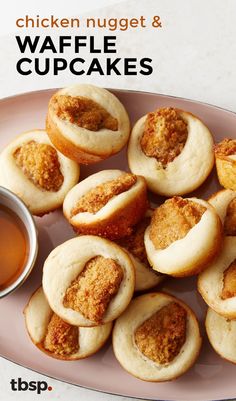 a pink plate topped with cupcakes next to a bowl of tea and sauce