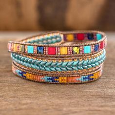 multicolored beaded leather wrap bracelets on a wooden table with a wood background