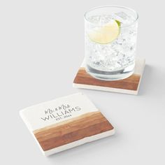 two personalized coasters with wood and ice on them, one has a slice of lemon in it