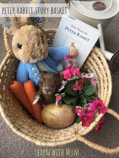 a basket filled with stuffed animals and flowers next to a sign that reads peter rabbit story basket