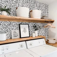 a washer and dryer in a room with black and white wallpaper on the walls