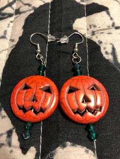 two carved pumpkins are hanging from earrings