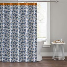 a shower curtain with blue and white leaves on it