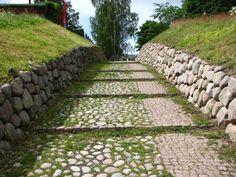 stone steps leading up to the top of a hill with grass growing on each side