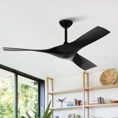 a black ceiling fan in a living room with bookshelves and plants on the shelves