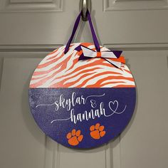 a door hanger with an orange and purple zebra print on it that says, skyflar & hannah