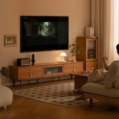 a woman sitting on a couch watching tv