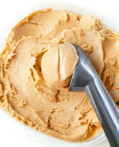 a spoon in a bowl filled with peanut butter