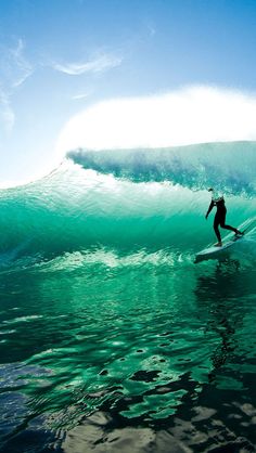 a person riding a surfboard on a wave in the middle of the ocean,