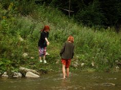 two people are walking through the water