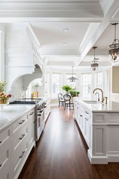 an open kitchen with white cabinets and wood floors is featured on the instagram page