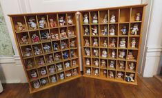 an open bookcase filled with small figurines on top of wooden flooring