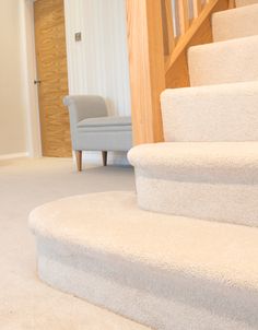 a carpeted staircase leading up to a blue chair