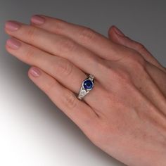 This delightful ring is centered with one (1) round mixed cut natural sapphire set into a half-bezel setting. The top face of the shank is accented with four (4), channel set, round brilliant cut diamonds. The ring measures 9.4mm at the top, rises 7.1mm above the finger, tapering to 3.4mm wide and 1.6mm thick at the base of the shank. This ring is currently a size 6.5. The sapphire shows light abrasions. Platinum Channel Set Round Cut Jewelry, Luxury Round Stone Sapphire Ring For Anniversary, Diamond Sapphire Ring With Channel Set For Anniversary, Sapphire Ring With Channel Set Diamonds For Anniversary, Fine Jewelry Sapphire Diamond Ring With Round Stone, Channel Set Sapphire Ring With Diamond For Anniversary, Blue Sapphire Ring Channel Set, Luxury Sapphire Rings Channel Set, Luxury Sapphire Ring With Round Stone