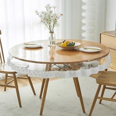 a dining table with two chairs and a bowl of fruit on the plate next to it