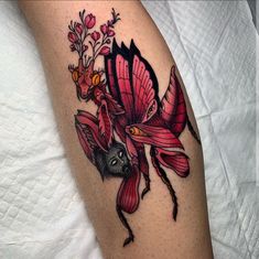 a close up of a tattoo on the leg of a person with flowers in it