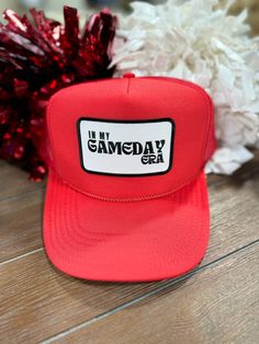 Red embroidered “In My Gameday Era” patch trucker hat. Mesh back with adjustable snap closure. One size fits most. Red Trucker Hat With Letter Print For Baseball Season, Game Day Trucker Hat For Baseball Season, Adjustable Snapback Trucker Hat For Game Day, Game Day Trucker Hat With Letter Print, Red Letter Print Trucker Hat For Baseball Season, Red 5-panel Hat With Letter Print, Red Trucker Hat With Letter Print And Flat Brim, Casual Six-panel Trucker Hat For Game Day, Customizable Snapback Trucker Hat For Game Day