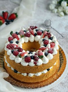 a cake with berries and whipped cream on top