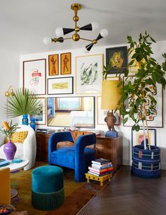 a living room filled with lots of furniture and pictures on the wall next to a potted plant