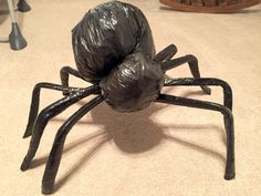 a black plastic spider sitting on the floor