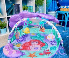 an inflatable play mat with ariel the mermaid on it and under water bubbles