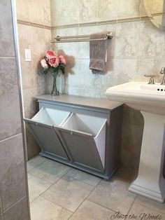 a bathroom with a sink, mirror and trash can