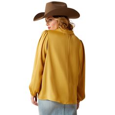 This elegant satin top has a flair for the dramatic. With its golden hue, glossy sheen, and billowy sleeves, it turns any outfit into a moment. The perfect plus-one for all your holiday events. Shimmer Top | Product Features : 0 : Elastic at cuffs | Women's Shimmer Top in Antelope Satin feel finish. 100% Polyester. Imported, Size: Large by Ariat Chic Sheen Tops For Fall, Chic Fall Tops With Sheen, Gold Silk Blouse For Fall, Chic Gold Satin Blouse, Fall Solid Silk Tops, Long Sleeve Sheen Blouse For Fall, Gold Fitted Blouse For Fall, Chic Gold Satin Top, Fall Long Sleeve Blouse With Sheen