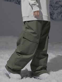 a person standing in the snow wearing green pants and white shoes with their feet up