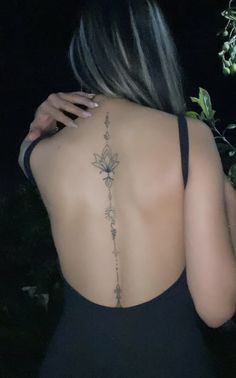 the back of a woman's body with tattoos on her upper and lower back