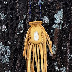 Handmade Native American style dyed elk hide medicine bag with glass seed bead necklace and white tail antler medallion. 28" strong synthetic sinew string necklace. Bag is 2 1/2" long and 1 " wide at the opening with adjustable drawstrings. Fringe is 4" long.  Traditionally, a medicine bag would be worn by a Native American shaman, or medicine man, as a container for items that held supernatural power. For others, the medicine bag would carry various items, such as animal furs, stones, or other Hand Tooled Bohemian Jewelry For Everyday, Bohemian Hand Tooled Jewelry For Everyday Use, Bohemian Beaded Necklaces For Everyday, Glass Seed Bead Necklace, Leather Medicine Bag, Medicine Man, String Necklace, Supernatural Power, Animal Fur