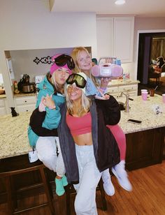 three women are posing for a photo in the kitchen