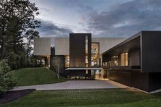 the exterior of a modern house with large windows and dark colored materials on it's facade